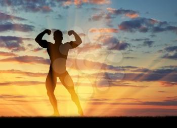 Concept of beauty and sports. Silhouette of bodybuilder poses at sunset