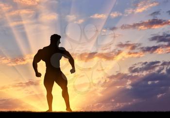 Concept of beauty and sports. Silhouette of bodybuilder poses at sunset