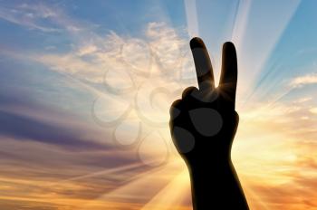 Concept of emotions and feelings. Silhouette hand gesture peace on sunset background