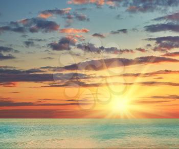 Beautiful sea sunset cloudy sky piercing rays of the sun