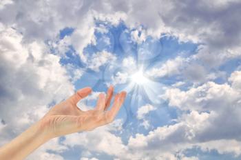 Concept. hands touches turns to the sky on solar background cloudy sky