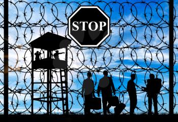 Concept of refugee. Silhouette of a crowd of refugees with things and fence with barbed wire and watch tower