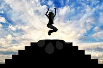 Concept of business success. Silhouette of a happy business woman in a jump at the top of the stairs