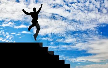Business success concept. Silhouette of a happy businessman jumping on the stairs