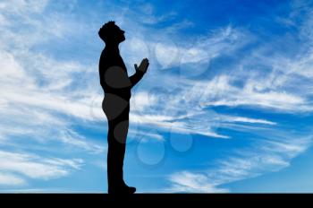 Silhouette of man praying at the sky looking at the sky background