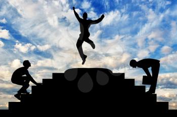 Concept of business success. Silhouette of a happy businessman jumping on top of the steps and the competition