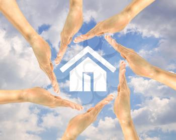Real estate concept. House icon in the hands of people on a background of clouds