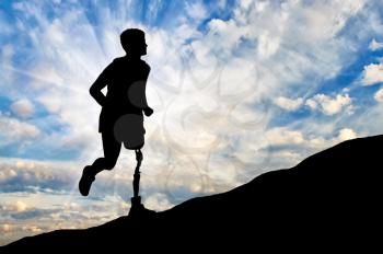Concept of disability. Man with prosthetic leg running up the hill