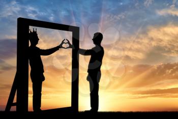 Silhouette of a narcissist man and hand gesture of a heart in reflection in the mirror and crown on his head. The concept of narcissism and selfishness