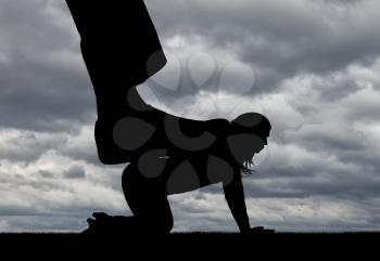 Silhouette of a large man's leg presses on a woman standing on all fours. The concept of discrimination and disrespect for women