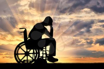 Silhouette of sad sad man in wheelchair in depression. The concept of people with disabilities experiencing dipression