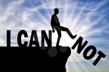 A man standing on a cliff pushes the word - I can not, he achieves the word - I can. Concept of motivation and success