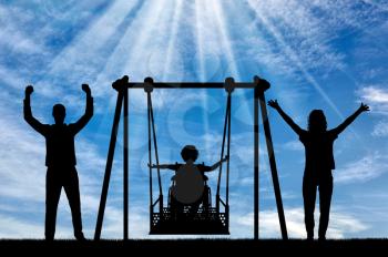 Silhouette of happy child is disabled in a wheelchair on an adaptive swing with mom and dad. have fun together. Concept of the lifestyle of children with disabilities and adaptive equipment for them