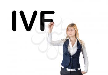 IVF. A woman writes the abbreviation in vitro fertilization. Conceptual image of in vitro fertilization