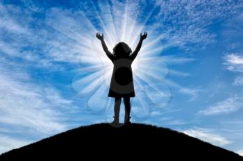 Silhouette, little happy girl child standing on a hill. Conceptual image of childhood
