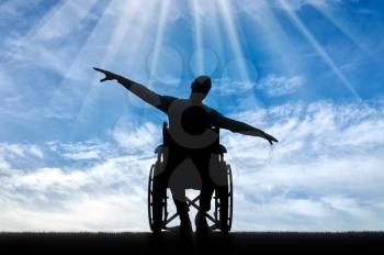 Silhouette of happy disabled man in wheelchair. The concept of happy people with disabilities