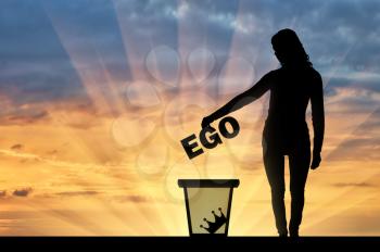 Silhouette of a woman throws the word ego into the garbage bin. The concept of selfishness as a bad habit from which it is necessary to refuse
