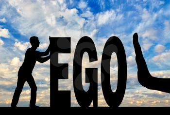 Gesture of the hand stop and silhouette of the man pushing the word ego. The concept of egoism as a problem in society