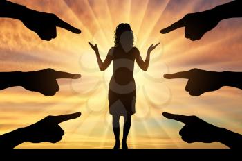 Workplace bullying concept. Silhouette of the hands shows fingers on a puzzled woman on a sunset background