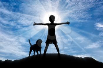 Happy childhood concept. Silhouette of a happy child on top of a hill at sunset with the dog