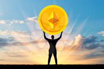 Silhouette of a man holding a coin ethereum against the sky. The concept of the future for crypto currency