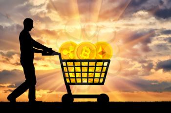 Silhouette of a man and a crypto currency in a grocery cart on a sunset background. The concept of purchasing crypto currency
