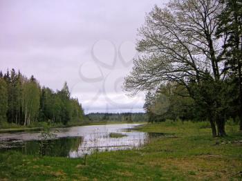 Cloudy spring landscape with the quiet river.