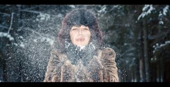 Girl blows away the snow from. Photo tinted.
