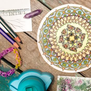 Hand-painted zendala, mandala among materials for creativity on a wooden table. Zentagle. Flat lay