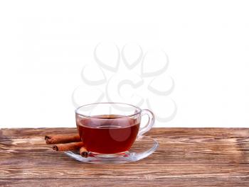 Glass cup of  tea with cinnamon sticks isolated on white