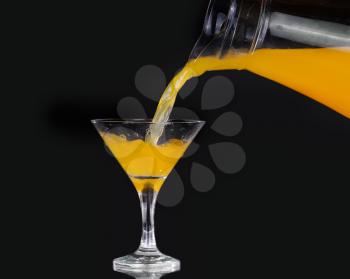 pouring orange juice into glass, Fresh pouring orange juice with fruits on black background