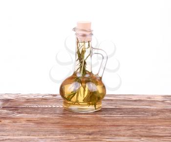 decanter with rosemary oil on wooden table