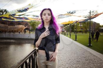Beautiful young violet hairy girl walking at sunset in a city park. St. Petersburg, New Holland
