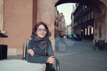Outdoor portrait of young beautiful lady posing on old street. Evening old Warsaw, Poland, spring