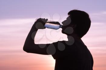 Rehydrate your body. male drinking a bottle of water.