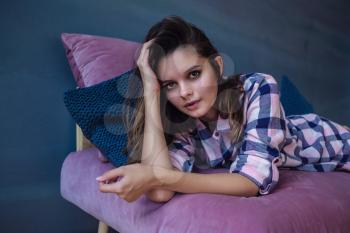 portrait of beautiful woman in sexy stylish lingerie and plaid shirt . Model with perfect sensual figure pose in home interior. Morning in bedroom. The idea and concept of pleasant leisure at home