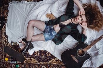 Beautiful Woman With Guitar In Rock Band in her room.