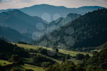 Summer mountain landscape in Slovakia. meadows with green grass, mountains, blue sky with clouds and sun. Highway in fields. Trip in europe. Travel