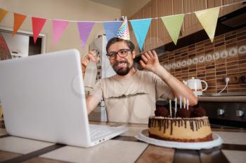 Man celebrating birthday online in quarantine time. Video conference party online meeting with friends and family. Birthday party in facetime call. Long Distance Celebration.