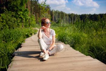 ginger charming woman young beautiful forest green. Caucasian girl relaxing and enjoying life on nature outdoors.