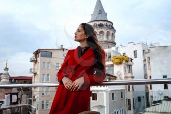 woman standing at the roof cafe with Istanbul on background, view of Galata tower in Beyoglu, Turkey. Travel and vacation in Turkey concept