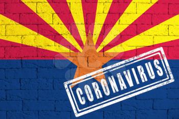 Flag of the State of Arizona painted on grungy brick wall background. with stamp CORONAVIRUS, idea and concept of healthcare, epidemic and disease in USA