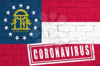 Flag of the State of Georgia painted on grungy brick wall background. with stamp CORONAVIRUS, idea and concept of healthcare, epidemic and disease in USA