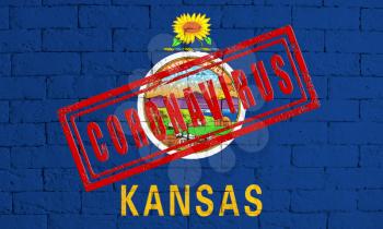 Flag of the State of Kansas painted on grungy brick wall background. with stamp CORONAVIRUS, idea and concept of healthcare, epidemic and disease in USA