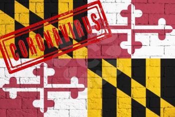 Flag of the State of Maryland painted on grungy brick wall background. with stamp CORONAVIRUS, idea and concept of healthcare, epidemic and disease in USA