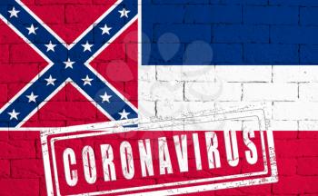 Flag of the State of Mississippi painted on grungy brick wall background. with stamp CORONAVIRUS, idea and concept of healthcare, epidemic and disease in USA