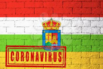 Flag of the regions or communities of Spain Rioja with original proportions. stamped of Coronavirus. brick wall texture. Corona virus concept. On the verge of a COVID-19 or 2019-nCoV Pandemic.