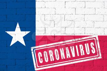 Flag of the State of Texas painted on grungy brick wall background. with stamp CORONAVIRUS, idea and concept of healthcare, epidemic and disease in USA