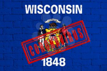 Flag of the State of Wisconsin painted on grungy brick wall background. with stamp CORONAVIRUS, idea and concept of healthcare, epidemic and disease in USA