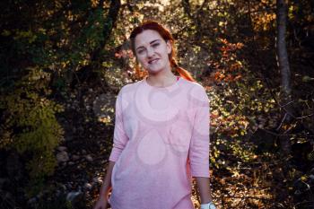 Beautiful young red-haired woman in the autumn forest. idea and concept of free time, happiness, care and freedom, outdoor activities and a healthy lifestyle